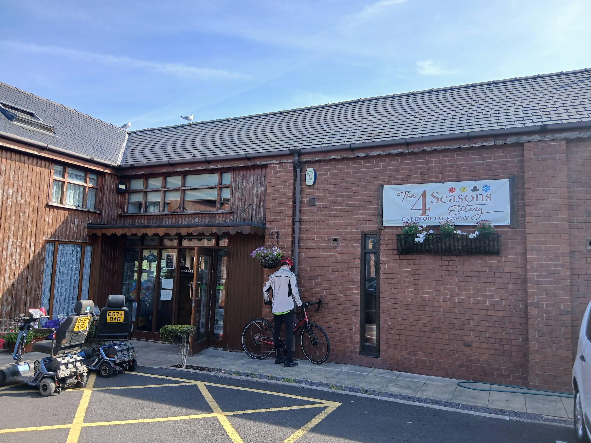 The full entrance and The 4 Seasons Eatery sign on the brick building