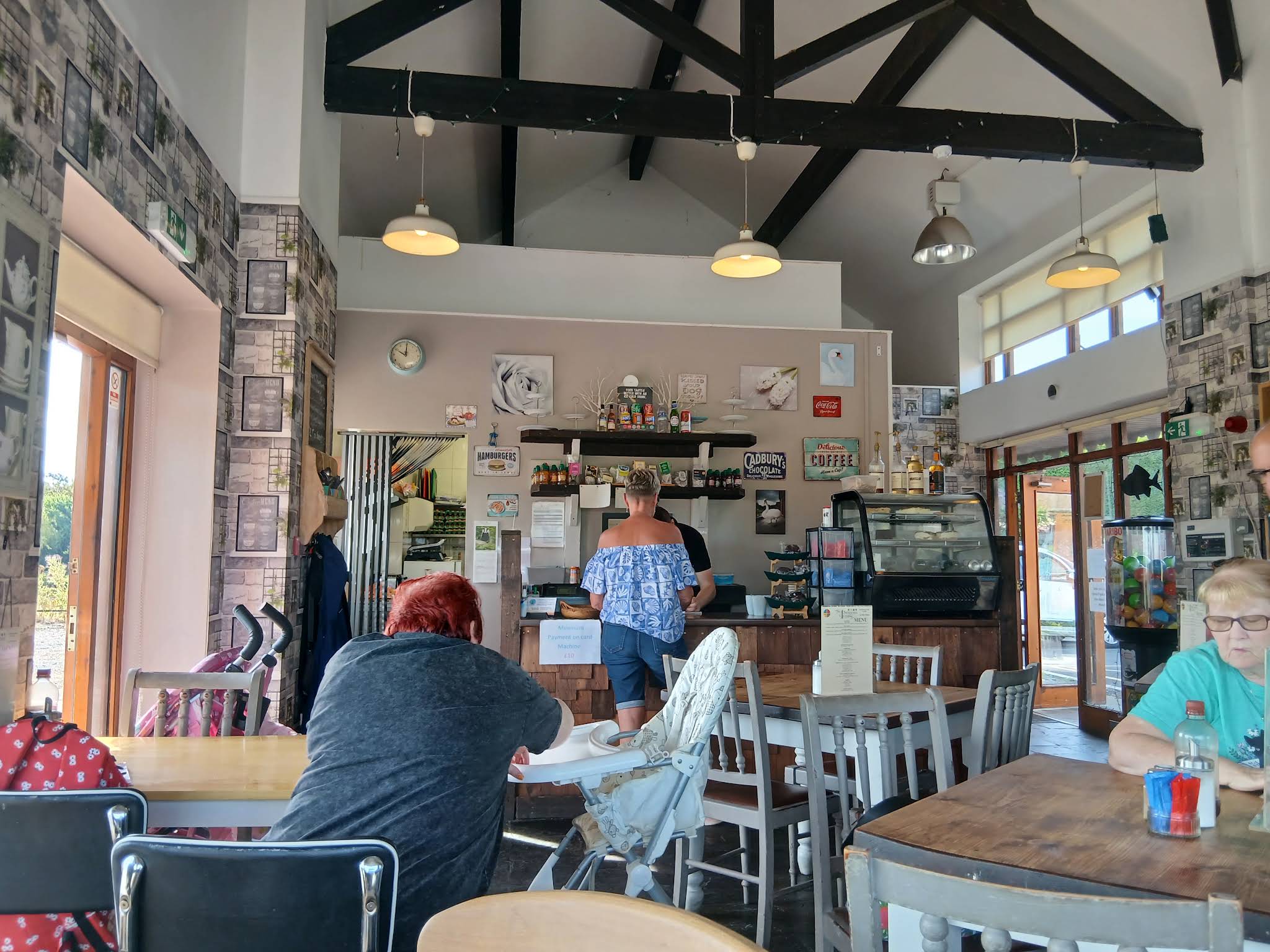 The eatery dining room with exposed timber beams, pendant lamps, tables and counter