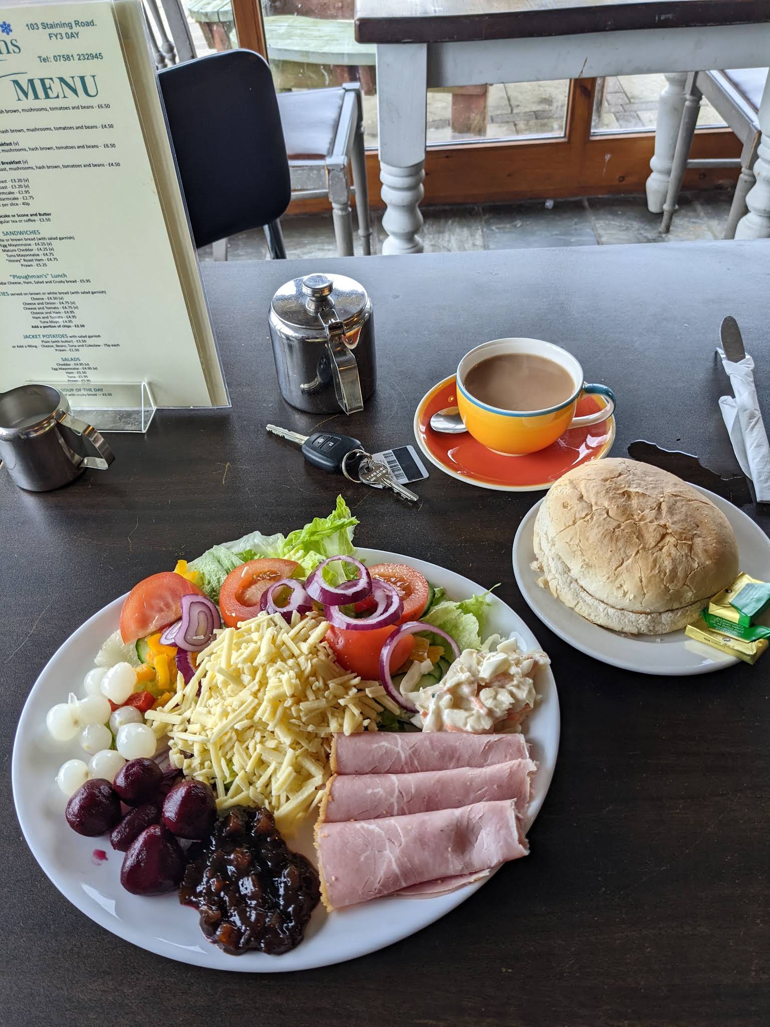A complete ham and cheese salad plate, bread roll and tea at the eatery